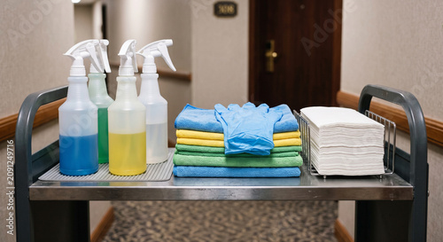 Cleaning cart top with spray bottles, folded cloths, towels, and supplies prepared for housekeeping and janitorial service