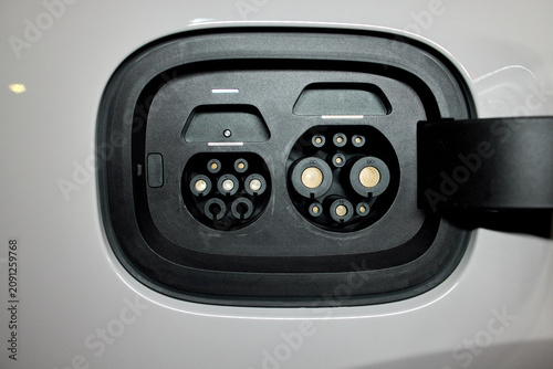 Electric car charging port, in vehicle exterior, with electric car, charging port, charger, with plastic, metal texture, from a close-up perspective, with black, white accents.