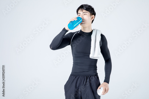 Bild auf Leinwand Athletic man drinking water after workout with towel on shoulder