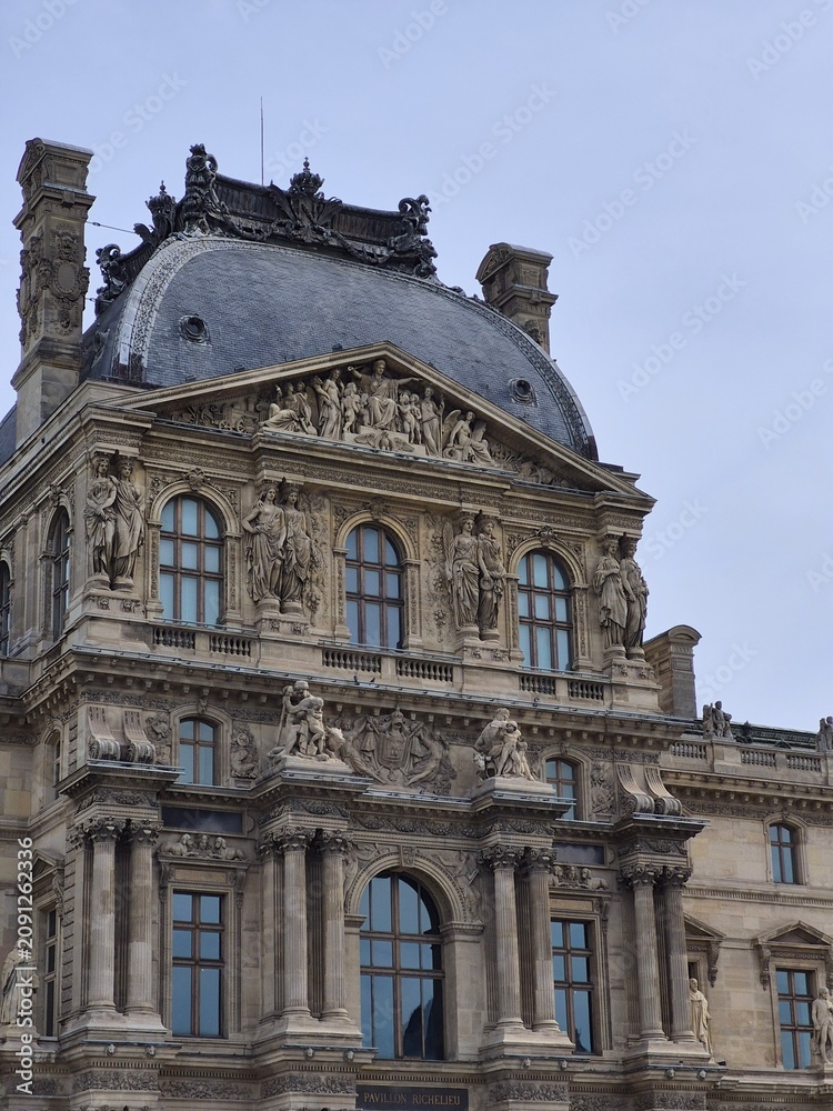 Obraz premium Sculptures and ornate facade of the Louvre Museum in Paris, France