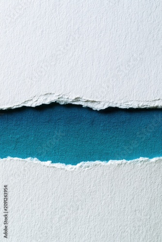 Torn white paper revealing a deep blue texture. This image is perfect for creative backgrounds and design.
