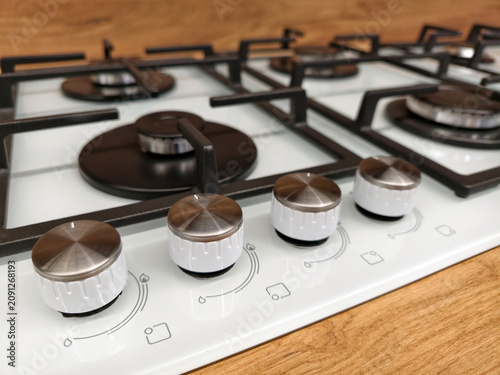 Fényképezés Close up on control knobs of a white built in gas cooker on display in a constru