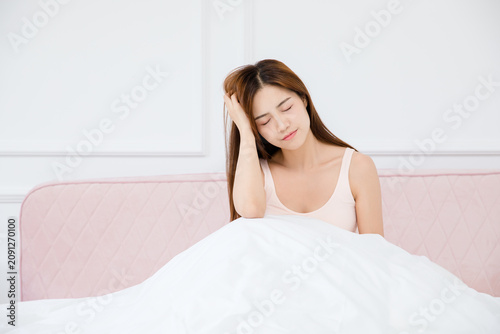 Konstfotografi Sleepy young woman waking up in bed at home