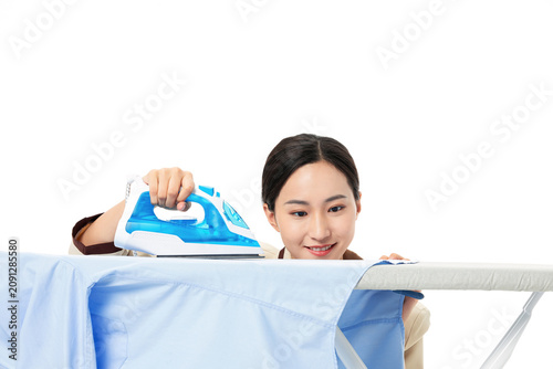 Konstfotografi Young woman ironing blue shirt on ironing board isolated on white