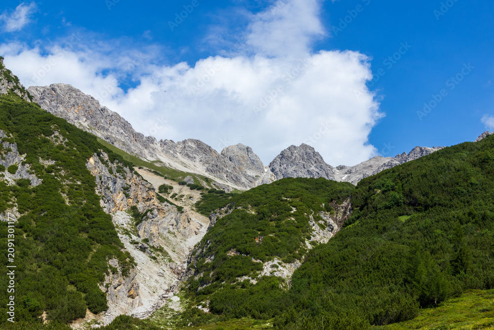 Fototapeta premium Rocky mountain landscape with alpine shrubs and clear sky, Italy, South Tyrol, Meran, 28 June 2026