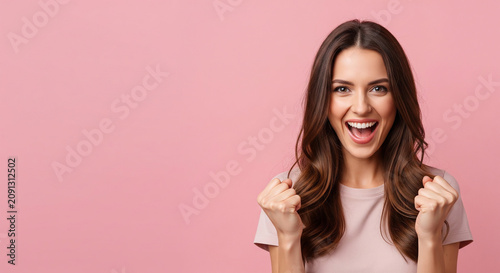 Overjoyed woman pumping her fists in the air celebrating a big win, perfect for victorious success and extreme happiness concepts