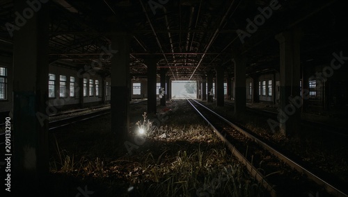 Old Train Station Shows Empty Tracks and Overgrown Plants During Late Hours