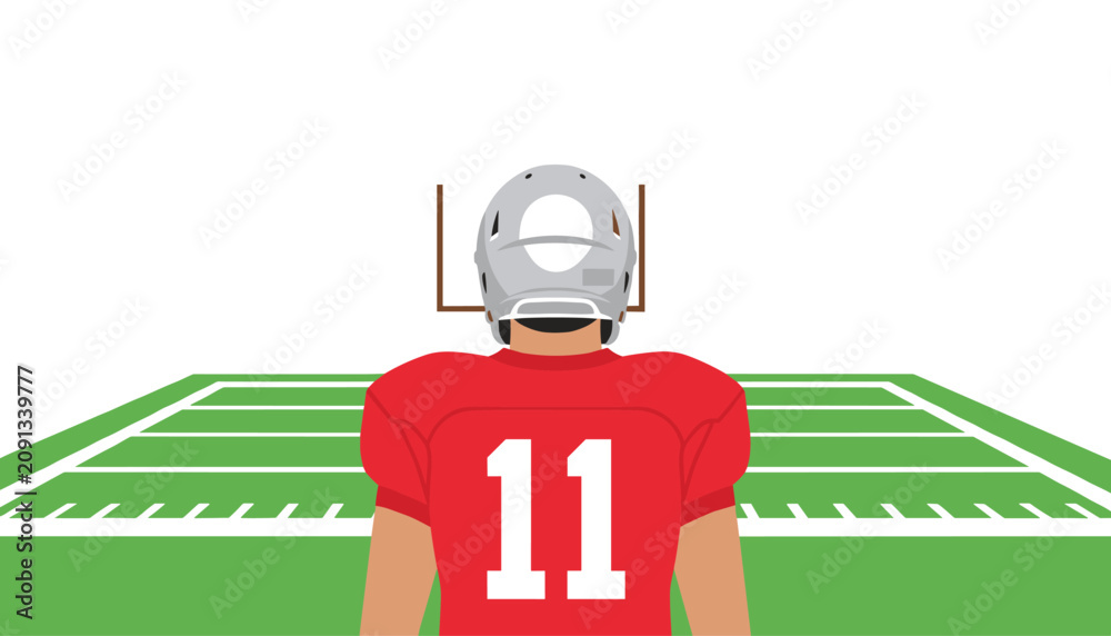 Fototapeta premium Football player wearing a red jersey with the number eleven on the back and a silver helmet standing on a field facing the goal posts.