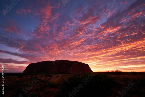 Majestic sandstone monolith at golden hour under dramatic clouds