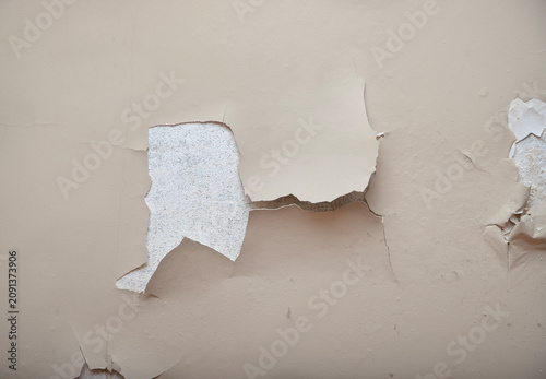 Severe flaking and peeling paint on an interior wall surface.