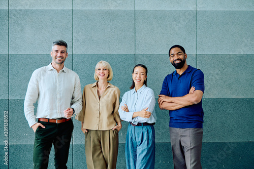 Fotografie Four smiling multi-ethnic businesspeople posing in business casual attire, repre