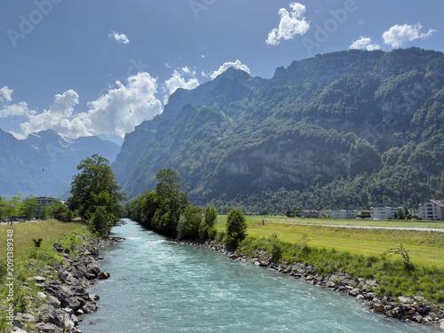 Cuadro en lienzo Turquoise Alpine River With Rocky Banks and Forested Mountain Peaks in the Glaru