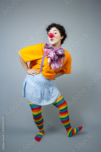 Young lady dressed as a clown. Studio portrait ideal for circus art, children's party, and fun entertainment.