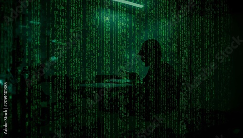 Person Sitting in a Room With Green Digital Code on Walls During Late Hours