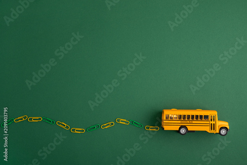 Yellow school bus driving along paperclip road