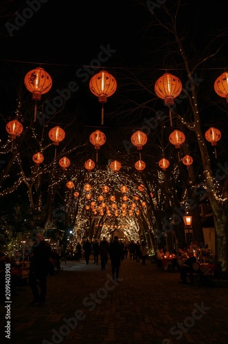 Snow Falls on a Busy Market Street During Night With Stalls and Lights
