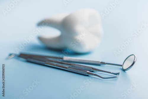 Dental Tools and Tooth Model on Blue Background for Oral Care and Dental Clinic Use
