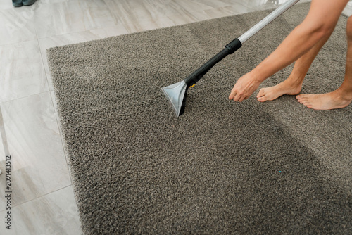 Cuadro en lienzo Person vacuuming thick gray shag carpet with upright cleaning tool, bare feet be