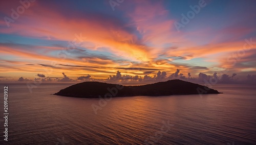 Sunset Over an Island With Colorful Clouds and Calm Waters in the Evening Sky