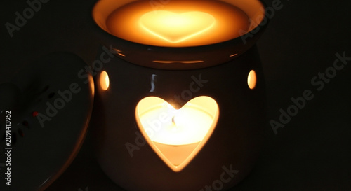 Glowing heart-shaped candle in dark setting