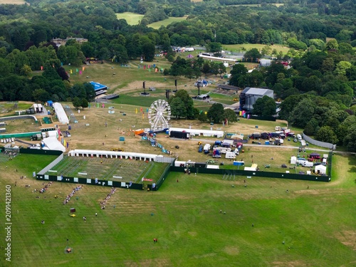 Aerial drone view of the concert site at Roundhay Park Leeds showing the main stage Ferris wheel event infrastructure and visitors arriving before a major summer music festival