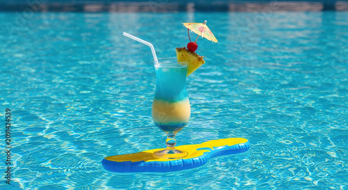 Tropical cocktail with pineapple garnish on inflatable pool float