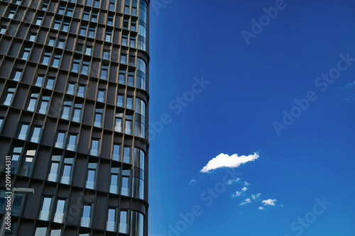 Photography A modern black metal facade of an apartment building with large windows set against a bright blue sky in Moscow's ZIL district