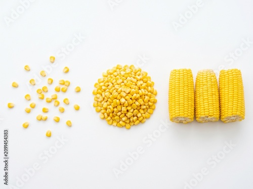 Crisp and delicious yellow corn kernels arranged beautifully on white, offering a vibrant raw ingredient visual for culinary blogs