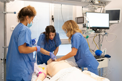 Fotografie Medical students practicing cpr on training mannequin in simulation lab
