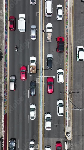 Vertical aerial top-down close-up of heavy traffic on the Viaducto in Mexico City, drone hovering at low altitude showing detailed cars flowing along the Viaducto avenue