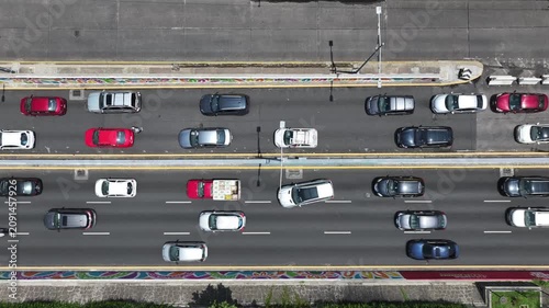 Aerial top-down close-up of heavy traffic on the Viaducto in Mexico City with the drone ascending vertically over the multi-lane avenue and moving cars