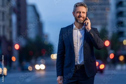 Businessman negotiation online, copy space. Man phone conversation in suit. Mature Hispanic business man with phone. Business communication of businessman. Business man talking on phone outdoor