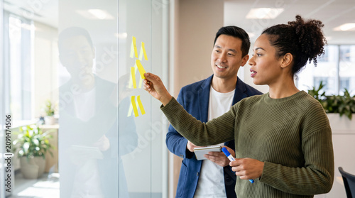 Diverse Business Team Collaborating on Project Management Strategy with Sticky Notes on Glass Wall in Modern Corporate Office Background for Creative Workshop Presentation Banner
