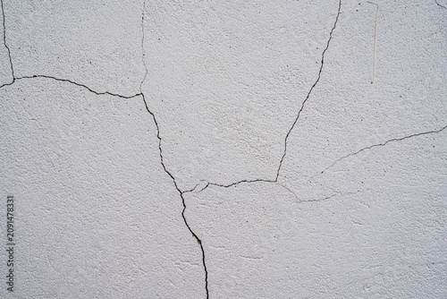 Foto Textura de pared blanca agrietada con grietas naturales en superficie de cemento