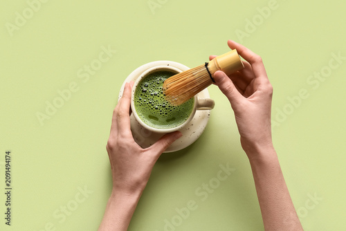 Woman preparing matcha tea ...