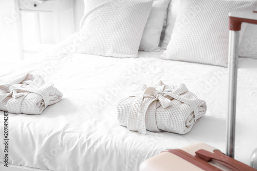 Folded bathrobes on bed in ...