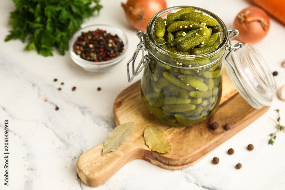 Fototapeta premium Jar with tasty pickled cucumbers and different spices on white background