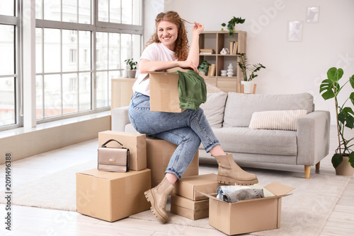Young woman with parcel boxes sitting at home