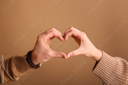Couple making heart gesture...