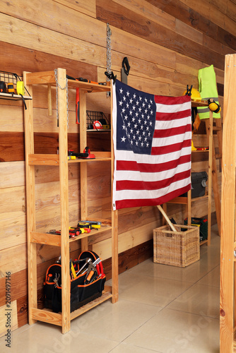Interior of carpenters workshop with USA flag and tools on shelves. Labor Day...