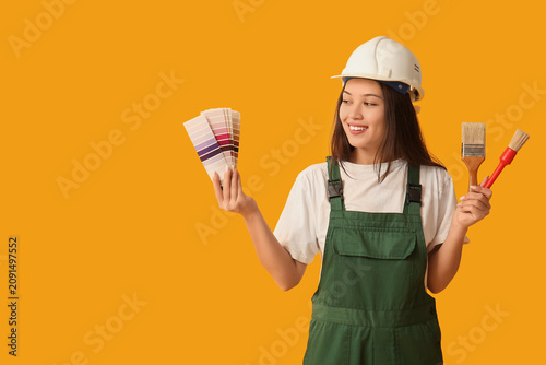 Konstfotografi Young female with painter with brushes and color swatches on yellow background
