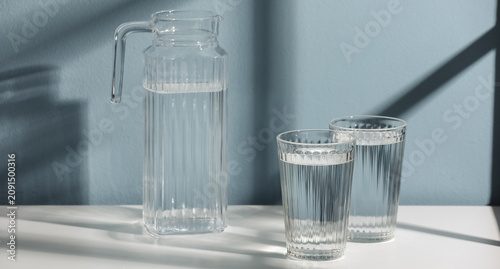 Glass pitcher and two drink...