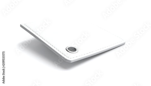 A white, square object with a metal ring on one corner is suspended at an angle, casting a shadow. It features a stitched edge