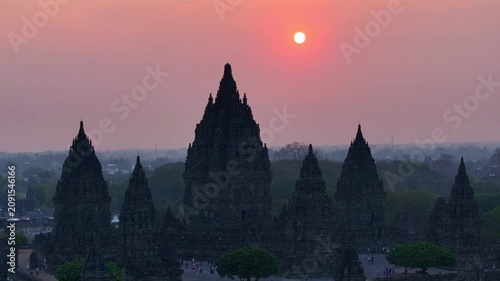 Cinematic aerial drone footage of Prambanan Temple during a vibrant sunset, showcasing ancient architecture, cultural heritage, and the breathtaking landscape of Yogyakarta, Indonesia.