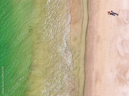 Aerial Drone View of Two People Walking Along Anna Maria Island Beach