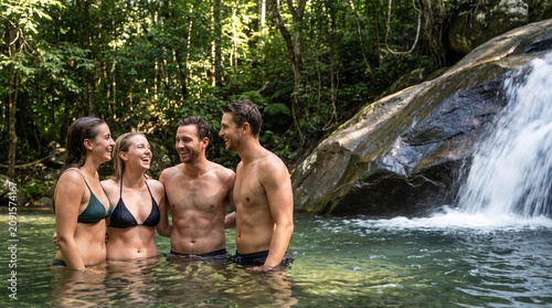 Medium close up of people in swimwear refreshing at forest waterfall mockup