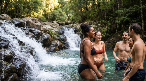 Medium close up of people in swimwear refreshing at forest waterfall mockup