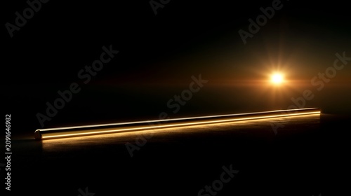 Golden metal rod illuminated by lens flare against a dark reflective background with copy space