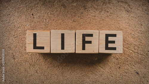 Konstfotografi Wooden blocks word LIFE textured natural background