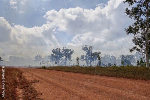 Cape York Queensland Australia dirt road through smoky bushland dramatic clouds